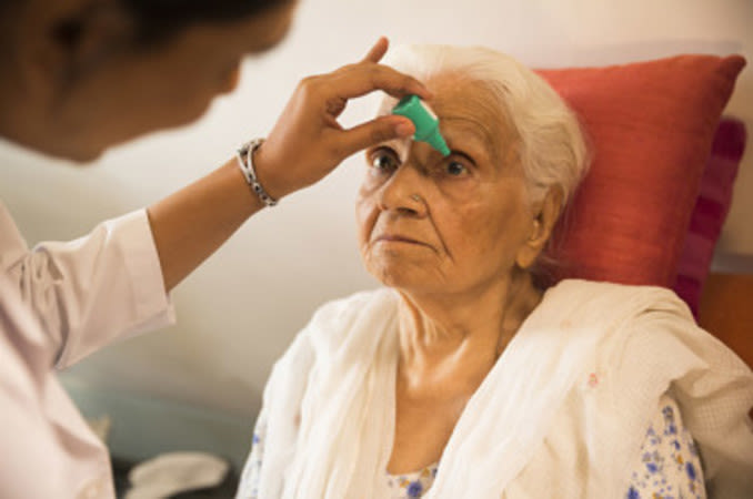 "Patient applying glaucoma eye drops as part of treatment at Shanthinethralaya Eye Hospital"